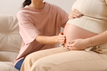 Doula tocando a barriga de gestante durante consulta de acompanhamento na gravidez